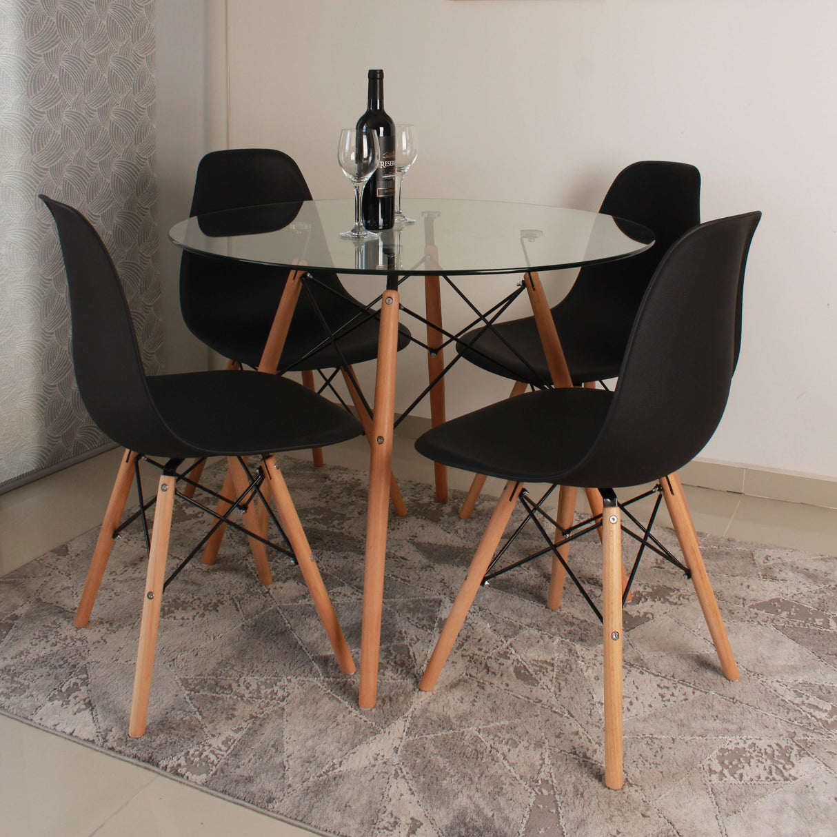 COMEDOR REDONDO TAPA VIDRIO MÁS 4 SILLAS DKR TIPO EAMES NEGRA